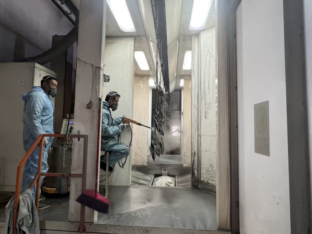 Manual powder coating spray line for aluminum die casting parts at Sureton surface treatment workshop.