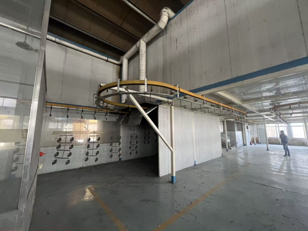 Surface Treatment Large-scale automated surface treatment production line with overhead conveyor system at Sureton factory.