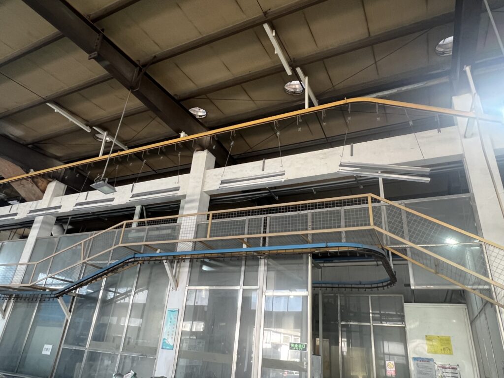 Surface Treatment Industrial overhead conveyor system for metal surface treatment and finishing processes at Sureton.